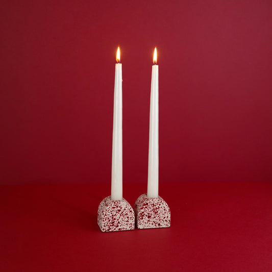 Burgundy paint splattered on a cream concrete small arch shaped candleholder, pair