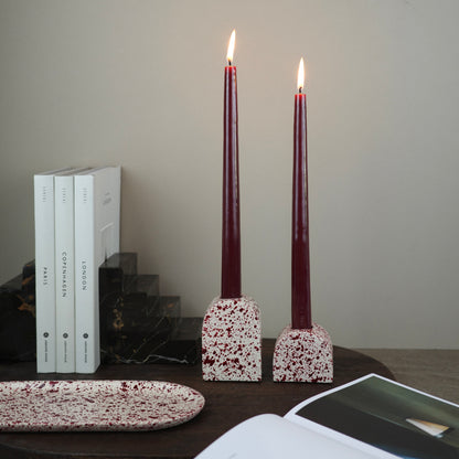 Burgundy paint splattered on a cream concrete small and large arch shaped candleholder