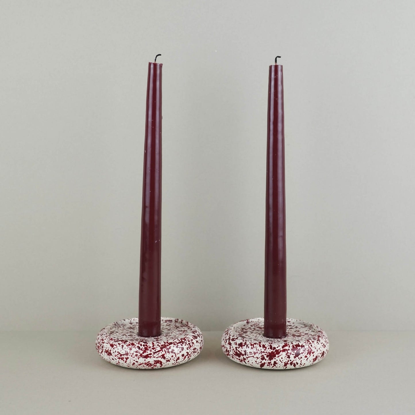 Burgundy paint splattered on a cream concrete circle shaped candleholder, stackable, pair