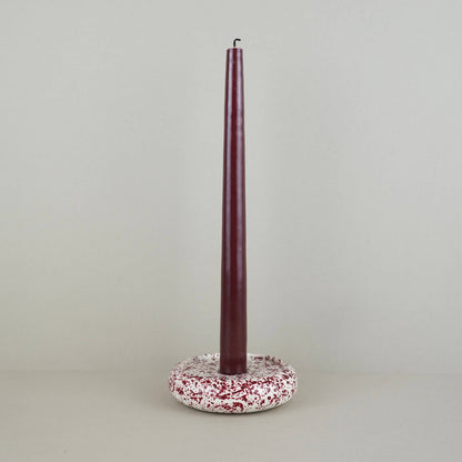 Burgundy paint splattered on a cream concrete circle shaped candleholder, stackable