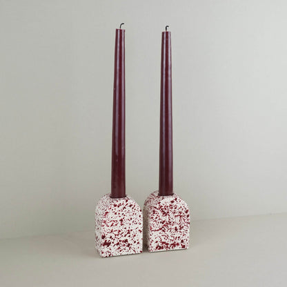 Burgundy paint splattered on a cream concrete large arch shaped candleholder, pair