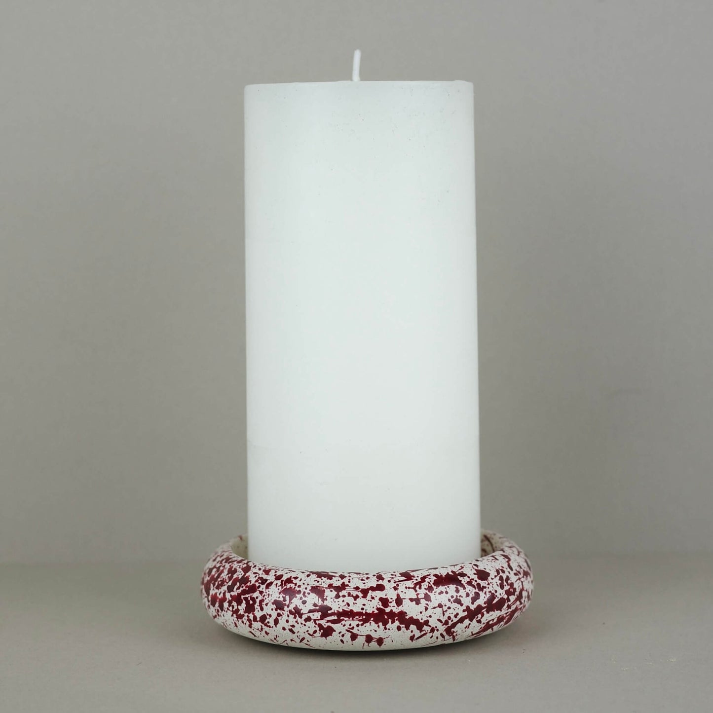 Burgundy paint splattered on a cream concrete circle shaped pillar candle holder stackable