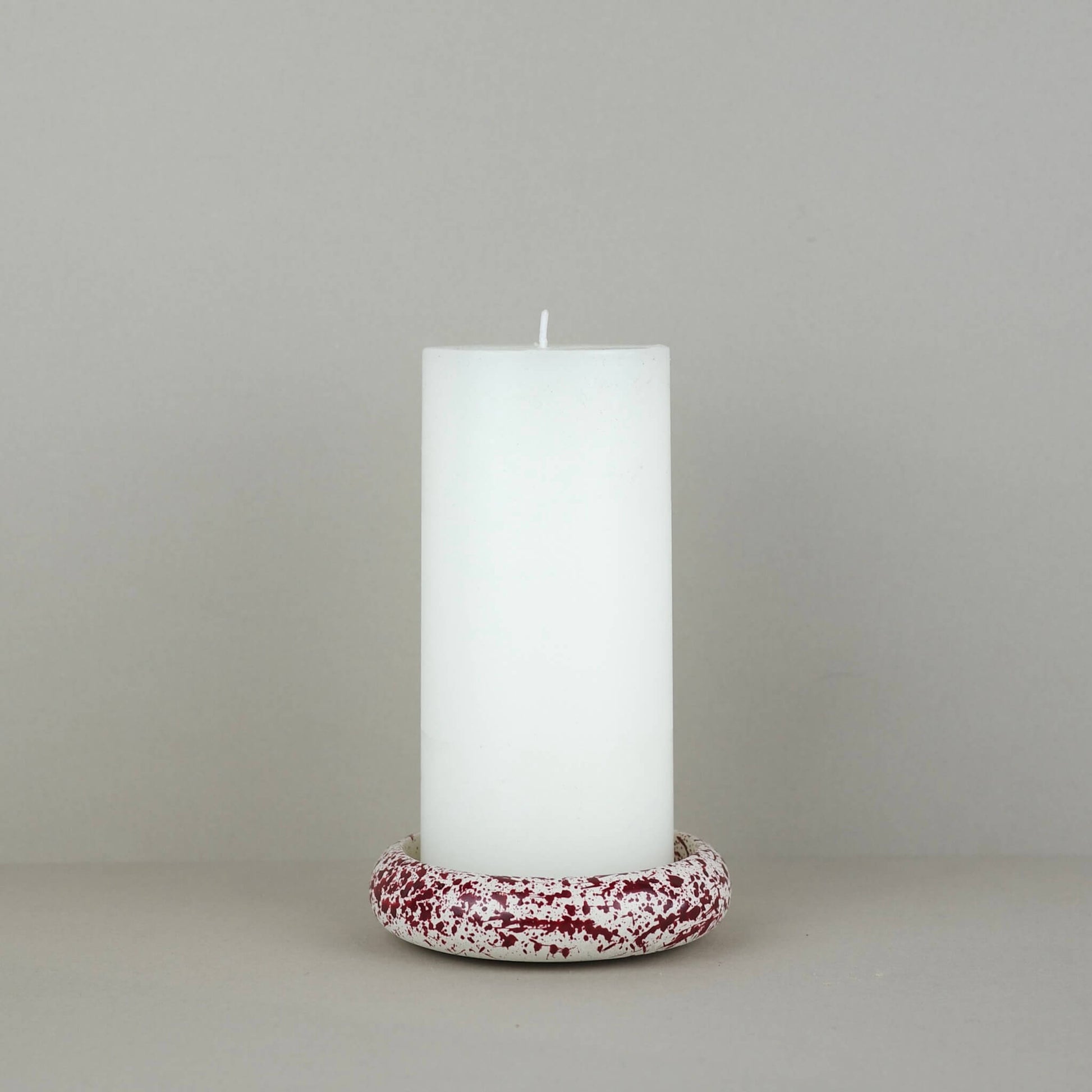 Burgundy paint splattered on a cream concrete circle shaped pillar candle holder stackable