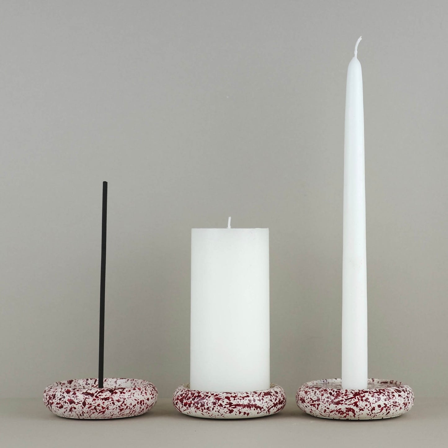 Burgundy paint splattered on a cream concrete circle shaped, incense holder,  pillar candle holder and candleholder, stackable