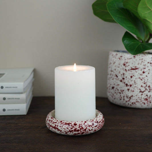 Burgundy paint splattered on a cream concrete circle shaped pillar candle holder stackable