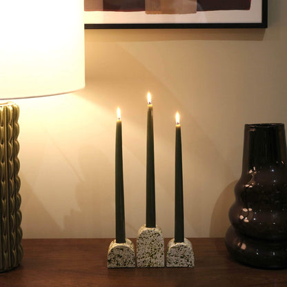 Green paint splattered on a cream concrete large arch shaped candleholder, pair