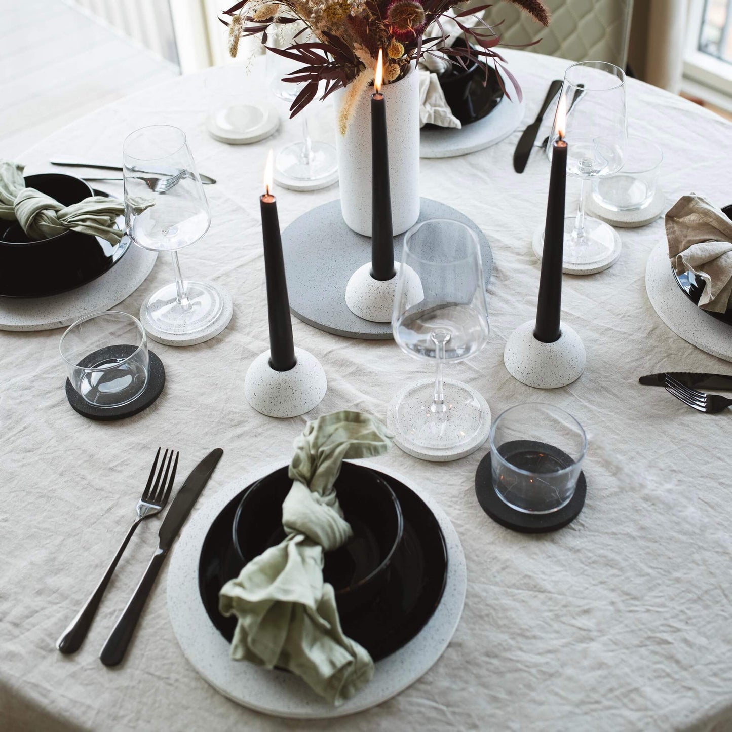 white eco concrete placemats, coasters and candlestick holders in a table setting